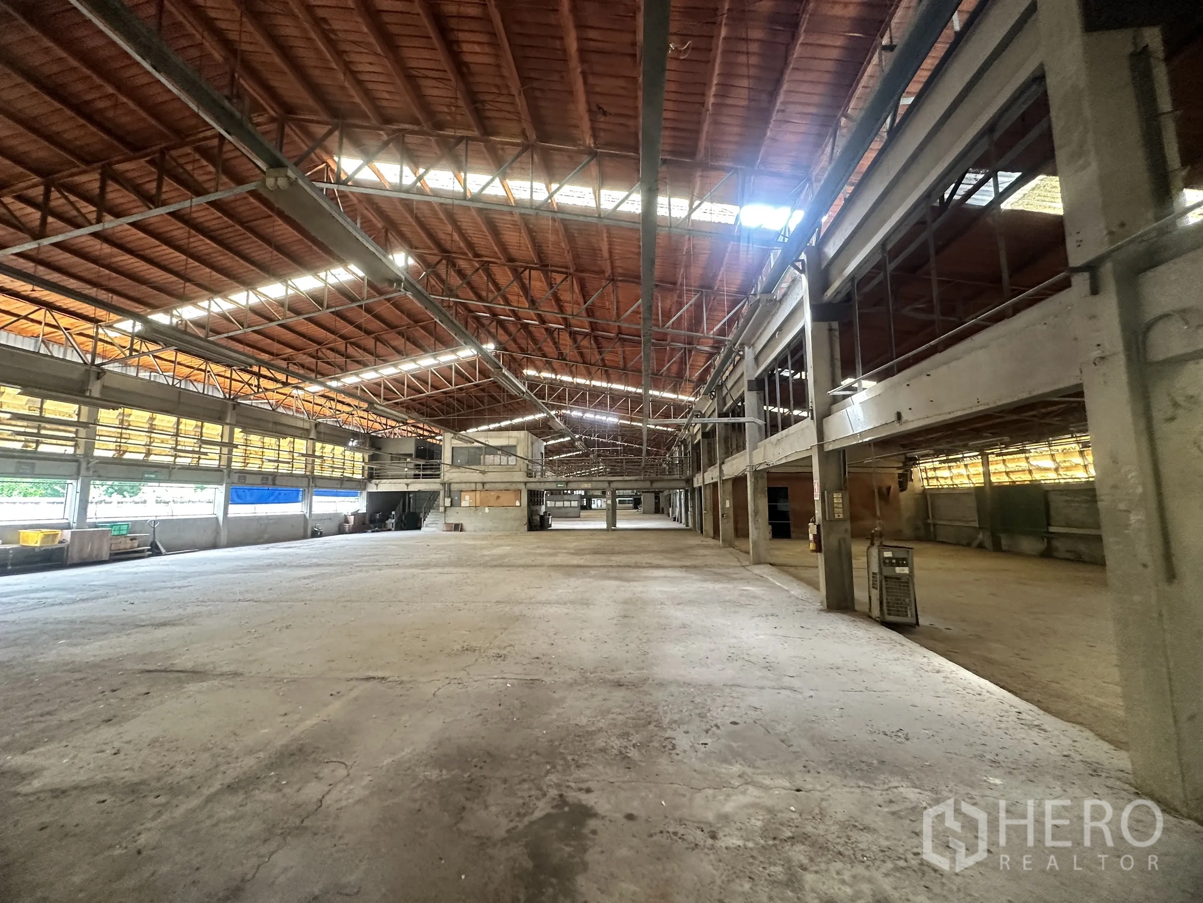 Factory for sale in Sai Noi, Nonthaburi - Expansive warehouse hall with open production area and roof skylights.