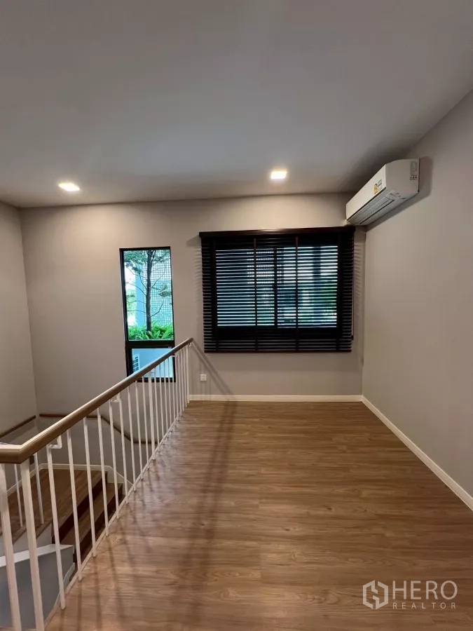 Detached House for rent in Samut Prakan - Spacious upstairs family area with window and air-conditioning.