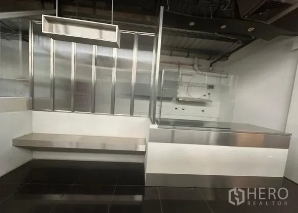Retail Space for rent in Bang Rak, Bangkok - Stainless-steel counter and display case with ribbed glass dividers and black tile flooring.
