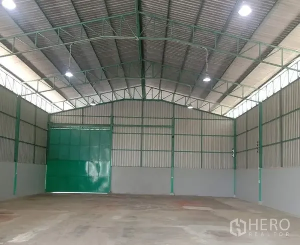 คลังสินค้า ให้เช่าในBang Bua Thong, Nonthaburi - พื้นที่เก็บสินค้าโล่ง ประตูบานเลื่อนสีเขียว ไฟไฮเบย์สว่าง