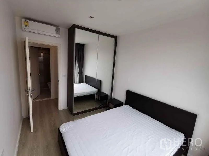 公寓 出租或出售在Din Daeng, Bangkok - 卧室配镜面衣柜，并与浴室相连。