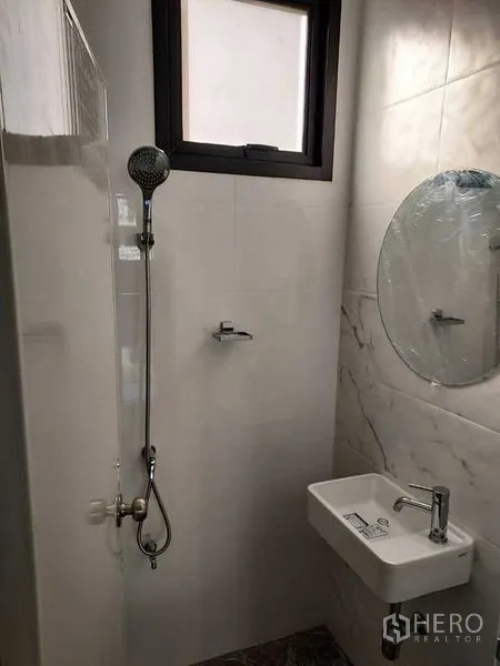 店屋 出租在Bang Kapi, Bangkok - 紧凑浴室，带淋浴、圆镜和洗手盆。