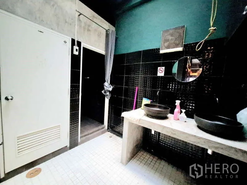 店屋 出租在Bang Rak, Bangkok - 浴室内双台上盆，黑色瓷砖重点墙，独立淋浴区。