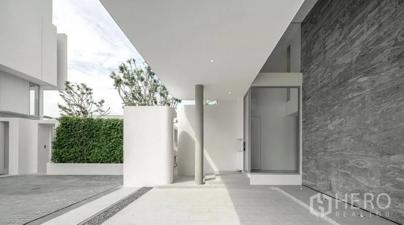 Detached House for sale in Saphan Sung, Bangkok - Covered carport and minimalist entryway with stone wall cladding.