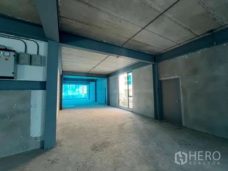 Retail Space for rent in Pathum Wan, Bangkok - Retail area showing electrical panel, concrete walls, large display-height windows and a side door.