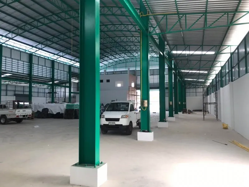 Factory for rent or sale in Mueang Samut Sakhon, Samut Sakhon - Interior perspective showing green columns and vehicle access through wide bays.