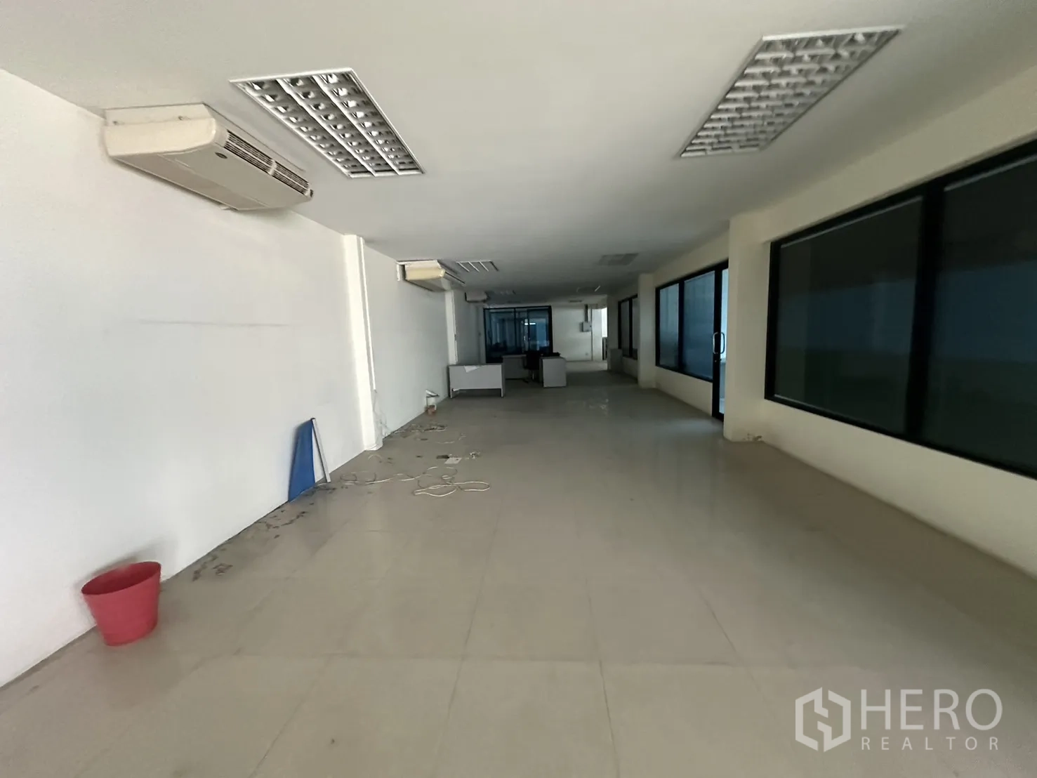 Factory for rent or sale in Prawet, Bangkok - Long air-conditioned office space with tiled floor, drop ceiling and large windows.