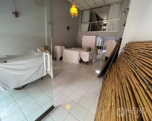 店屋 出租在Watthana, Bangkok - 前厅展示玻璃门、瓷砖地面与沿墙的竹质饰面板。