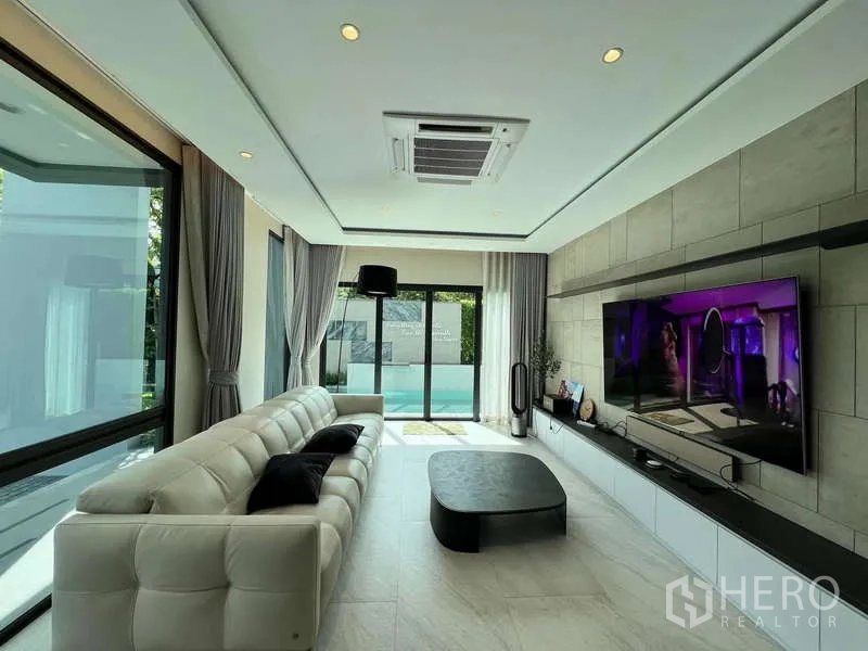 บ้าน ให้เช่าหรือขายในBang Kapi, Bangkok - ห้องนั่งเล่นติดสระ โซฟา ทีวีจอใหญ่ และกระจกเต็มบาน