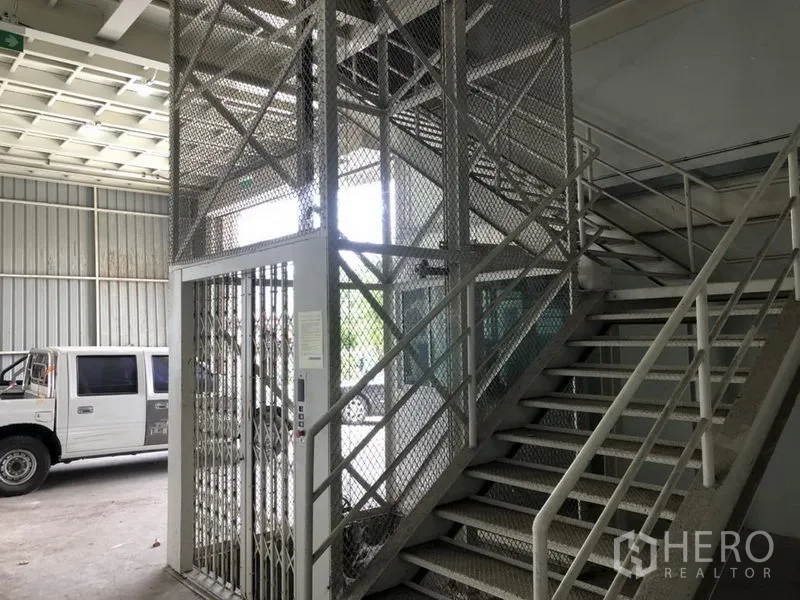 Home Office for rent in Bang Khen, Nonthaburi - Ground-floor staircase and caged lift structure next to the loading area.