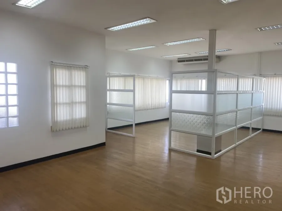 Office Space for rent in Khlong Toei, Bangkok - Bright open-plan office with wood floors, frosted glass partitions, large windows with vertical blinds, and ceiling lighting.