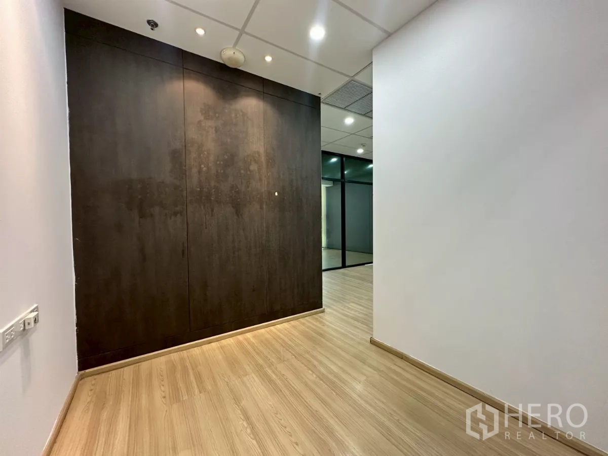 办公空间 出租在Watthana, Bangkok - 入口走廊，深色木质墙面、木地板与筒灯天花。