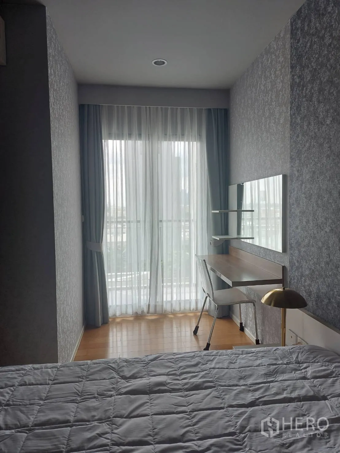 公寓 出租在Watthana, Bangkok - 卧室配床与书桌，推拉门通往阳台