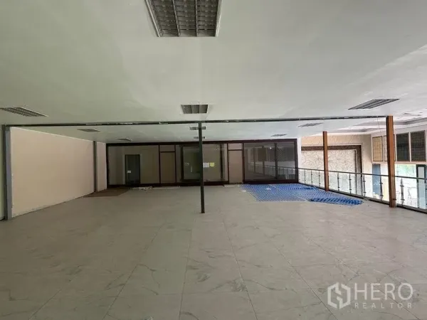 Warehouse for rent in Lam Luk Ka, Pathum Thani - Second-floor office mezzanine with glass balustrade and large tiled workspace.