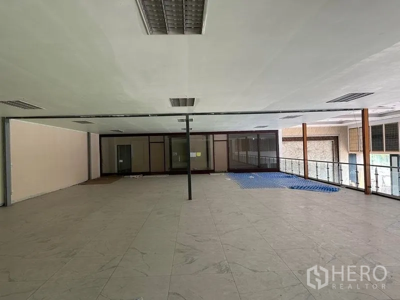 Warehouse for rent in Lam Luk Ka, Pathum Thani - Second-floor office mezzanine with glass balustrade and large tiled workspace.