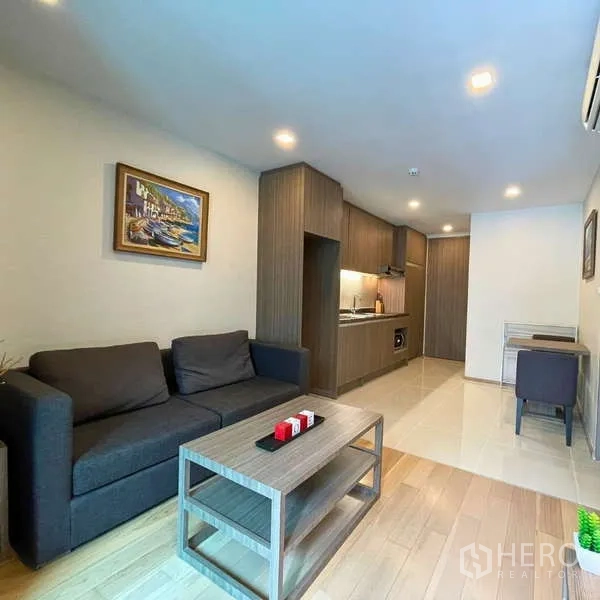 Condominium for rent - Sofa and galley kitchen with wood cabinetry and a small dining nook.