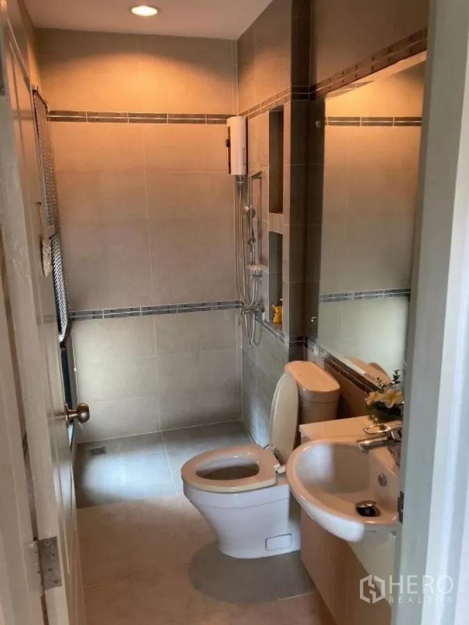 Detached House for rent in Mueang Nonthaburi, Nonthaburi - Tiled bathroom with enclosed shower, water heater, toilet and vanity basin.