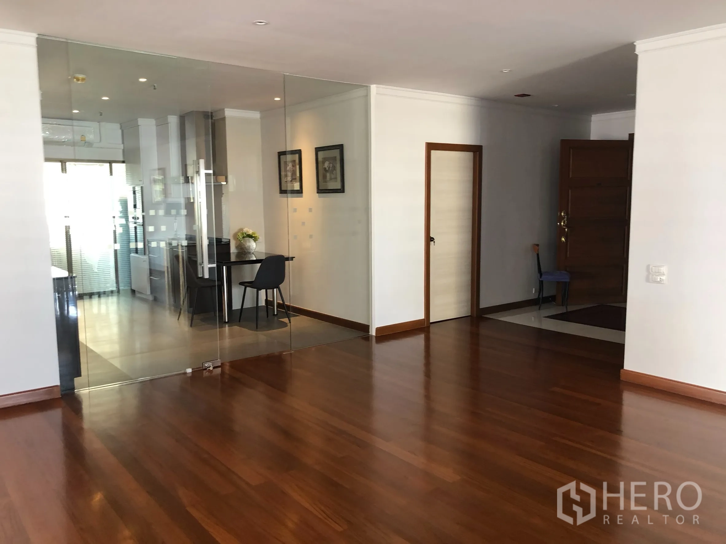 Condominium for rent in Bangkok - Entry foyer with glass-partitioned kitchen and solid wood entrance door.