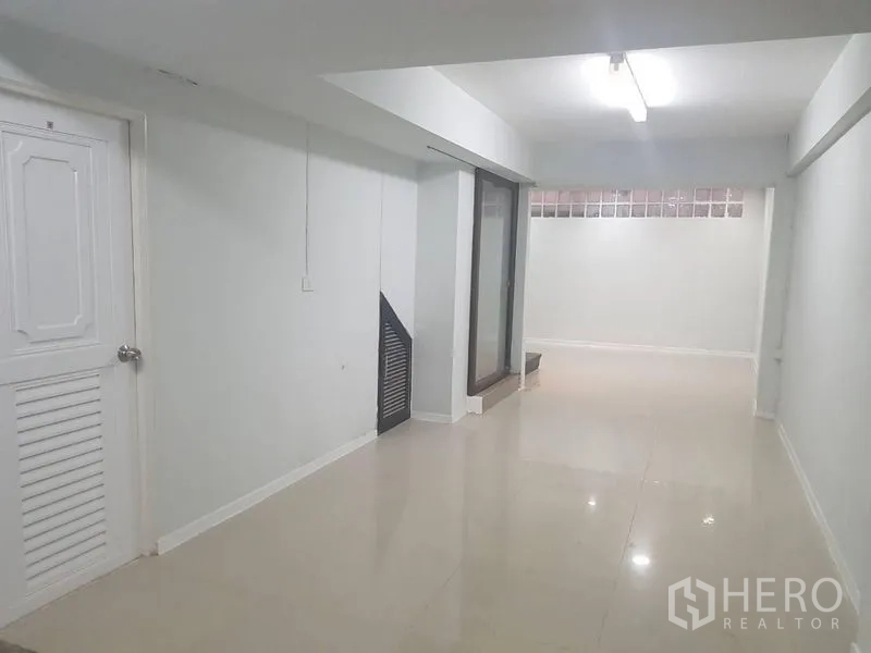 店屋 出租或出售在Lat Phrao, Bangkok - 走廊式空间，侧门与大尺寸地砖及顶灯。