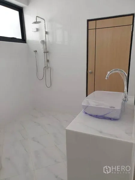 Home Office for rent or sale in Bang Na, Bangkok - White tiled bathroom with shower and glass basin.
