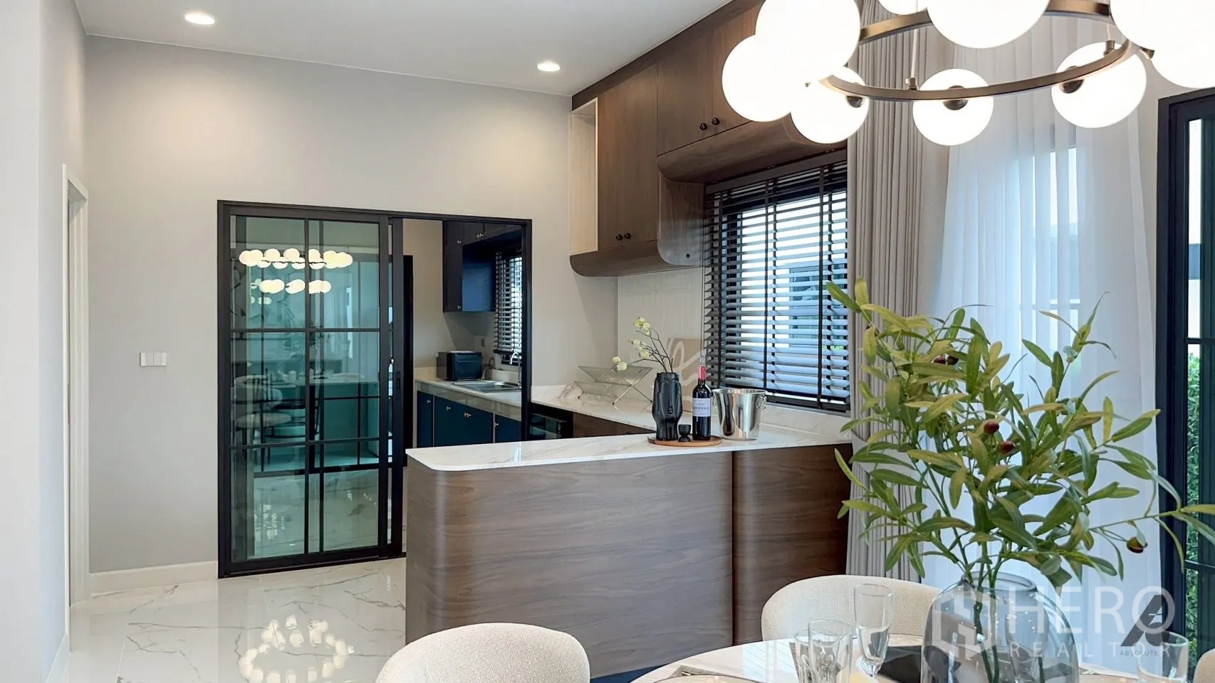 บ้าน ให้เช่าในBang Phli, Samut Prakan - พื้นที่ทานอาหาร โต๊ะกลม โคมไฟทรงลูกโลก พื้นลายหินอ่อน พร้อมเคาน์เตอร์แพนทรี่โค้ง