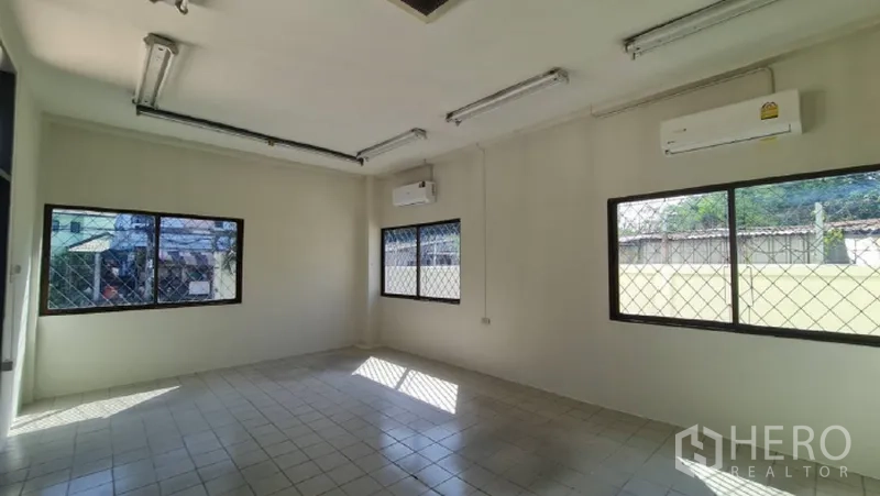Warehouse for rent in Khlong Toei, Bangkok - Air-conditioned office room with tiled floor and barred windows.