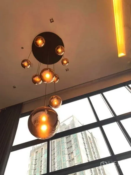 คอนโด ให้เช่าหรือขายในHuai Khwang, Bangkok - โคมไฟแขวนหลายดวงห้อยจากเพดานสูงใกล้ผนังกระจก