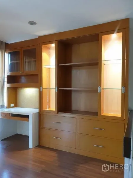 Townhouse for rent or sale in Yan Nawa, Bangkok - Built-in wooden display cabinet with glass doors and an integrated desk.