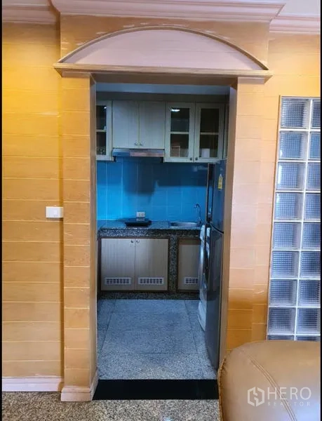 公寓 出租在Ratchathewi, Bangkok - 独立厨房，蓝色挡板、吊柜和冰箱。