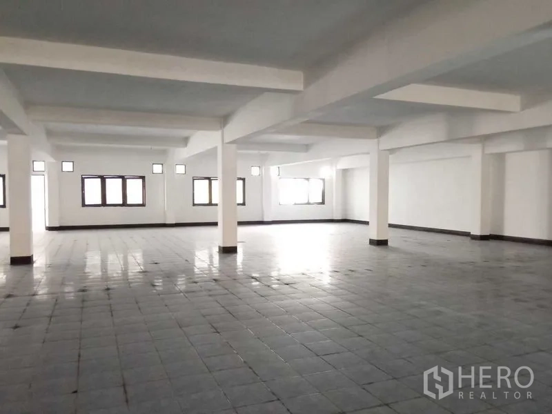 Warehouse for rent in Nong Khaem, Bangkok - Open-plan tiled warehouse area filled with natural light from multiple windows.