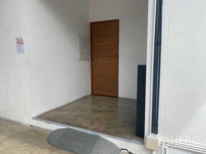 Home Office for rent or sale in Bang Khae, Bangkok - Side entrance with a wood door and polished concrete floor.