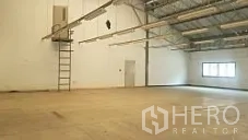 工厂 出售在Lam Luk Ka, Pathum Thani - 宽敞仓库大厅，高屋架与墙面梯子，工作区域开阔。