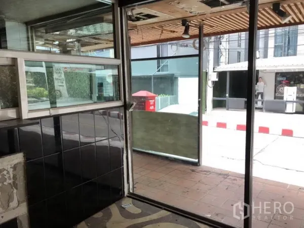 Retail Space for rent in Khlong Toei, Bangkok - Entry area showing sliding glass doors and tiled wall facing the sidewalk.