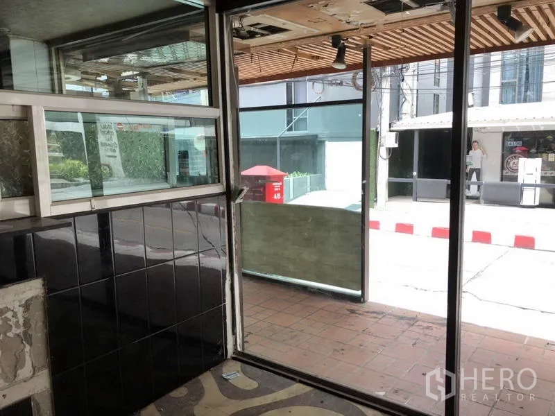 Retail Space for rent in Khlong Toei, Bangkok - Entry area showing sliding glass doors and tiled wall facing the sidewalk.
