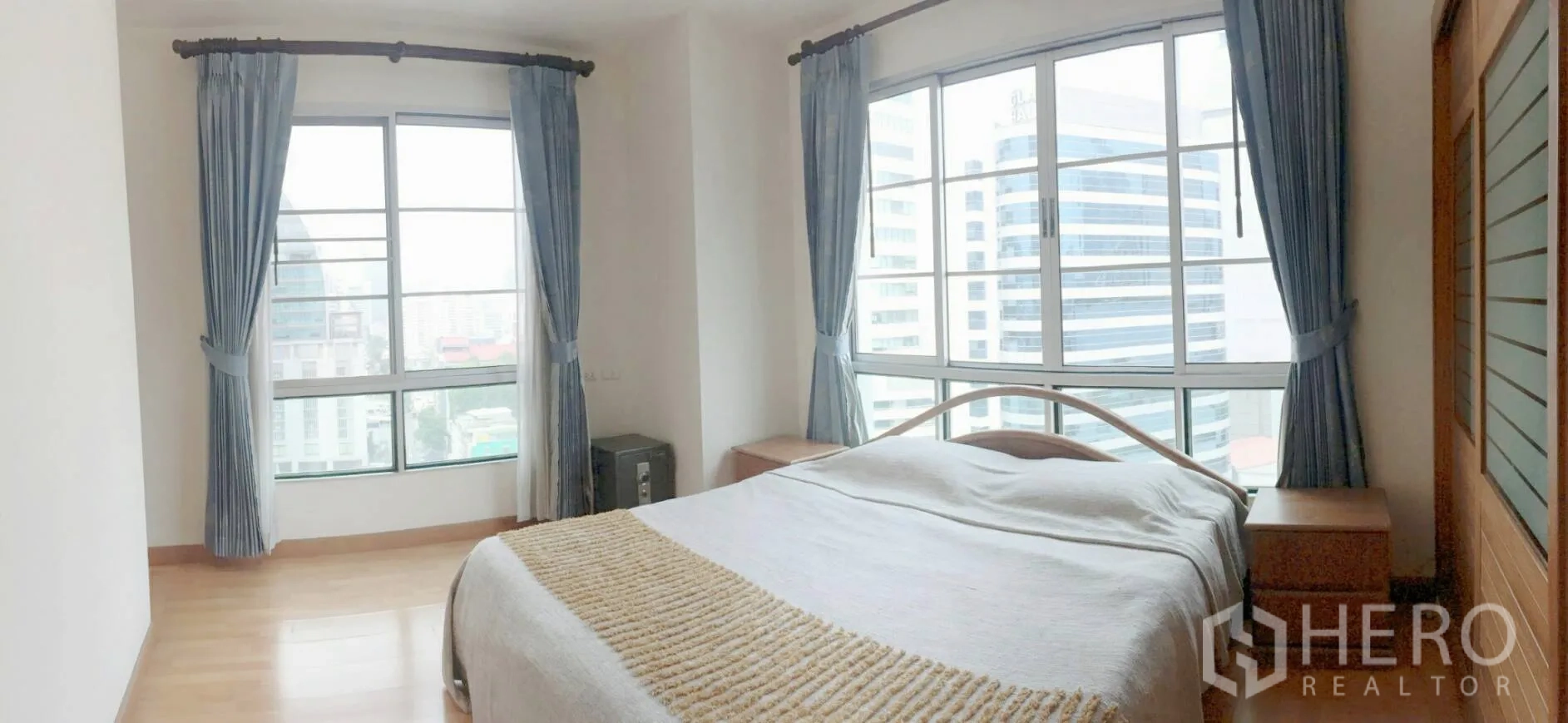 Condominium for rent in Khlong Toei, Bangkok - Bright master bedroom with large corner windows and panoramic city views.