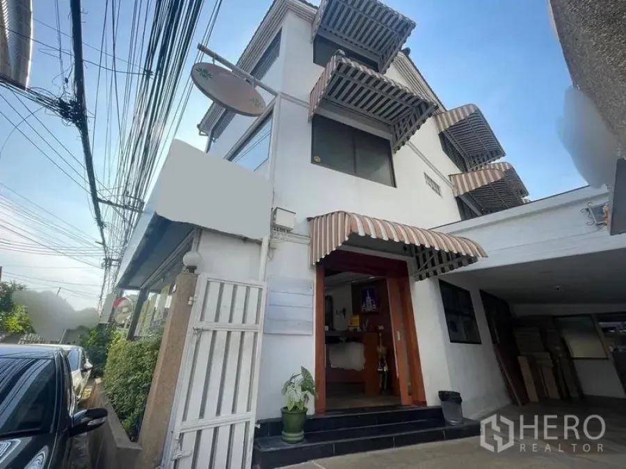 店屋 出租在Phaya Thai, Bangkok - 阿里三层商铺外观，条纹遮阳篷与带门的入口。