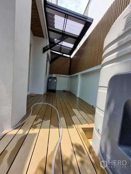 联排别墅 出租在Wang Thonglang, Bangkok - 侧院露台，防腐木地板与遮雨棚、储水罐。