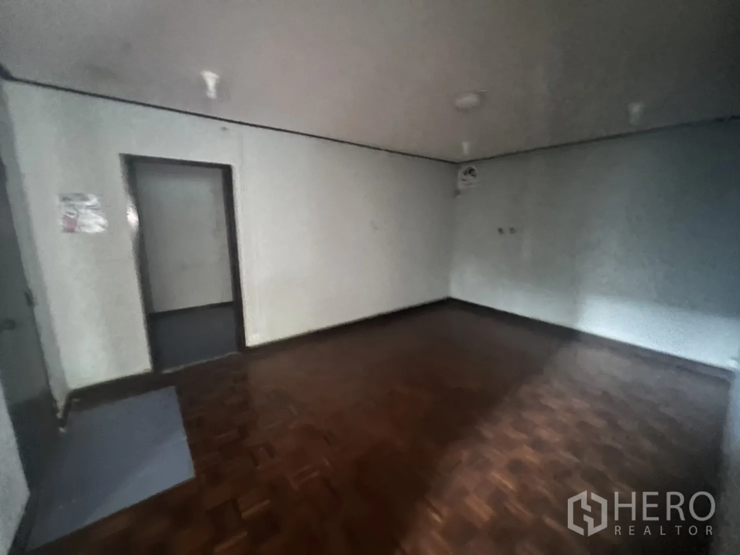 带办公室的家 出租在Watthana, Bangkok - 昏暗房间，拼花木地板与素色墙面。