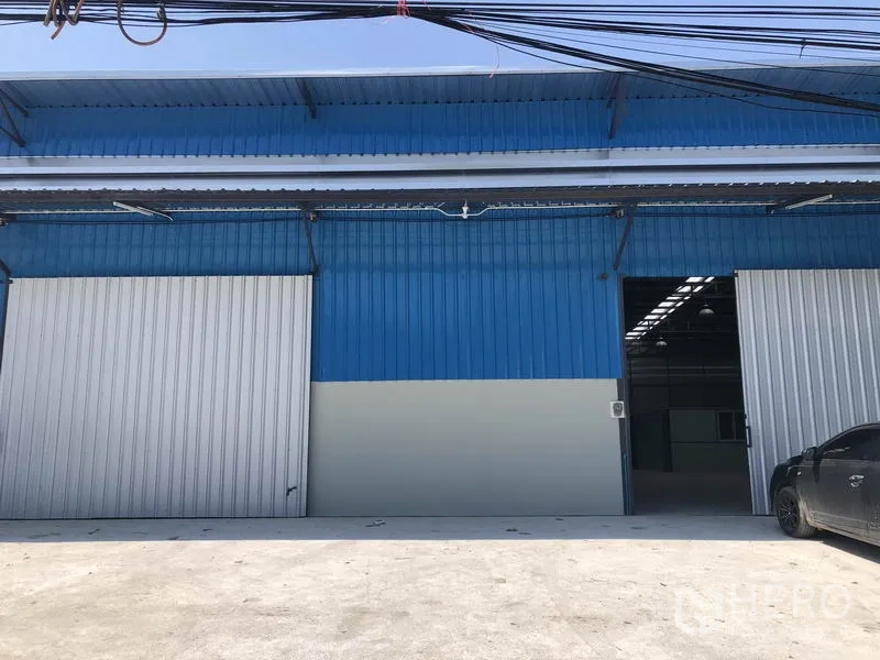 货栈 出租在Nonthaburi - 暖武里府帕克烈蓝色金属外立面仓库，配大滑门与装卸前坪。