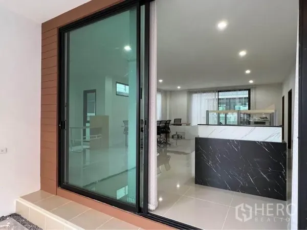 Home Office for rent in Bang Phli, Samut Prakan - Sliding glass door opening to bright lobby with marble reception counter and office area.