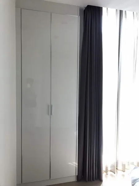 คอนโด ให้เช่าหรือขายในWatthana, Bangkok - ตู้เสื้อผ้าบิวท์อินสีขาวข้างหน้าต่างกระจกสูงพร้อมผ้าม่านทึบ