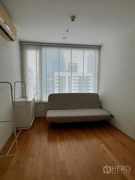 Condominium for rent in Ratchathewi, Bangkok - Second bedroom or study with futon sofa and wide window with city view.