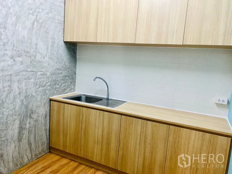 Office Space for rent in Bang Rak, Bangkok - Built-in pantry with sink, wood cabinetry and a white tile backsplash.