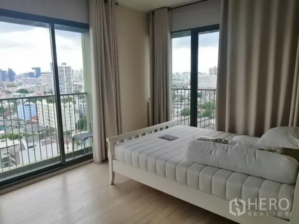 คอนโด ให้เช่าในWatthana, Bangkok - ห้องนอนเตียงสีขาว กระจกบานใหญ่จรดพื้นและระเบียง มองเห็นวิวเมืองกว้าง.