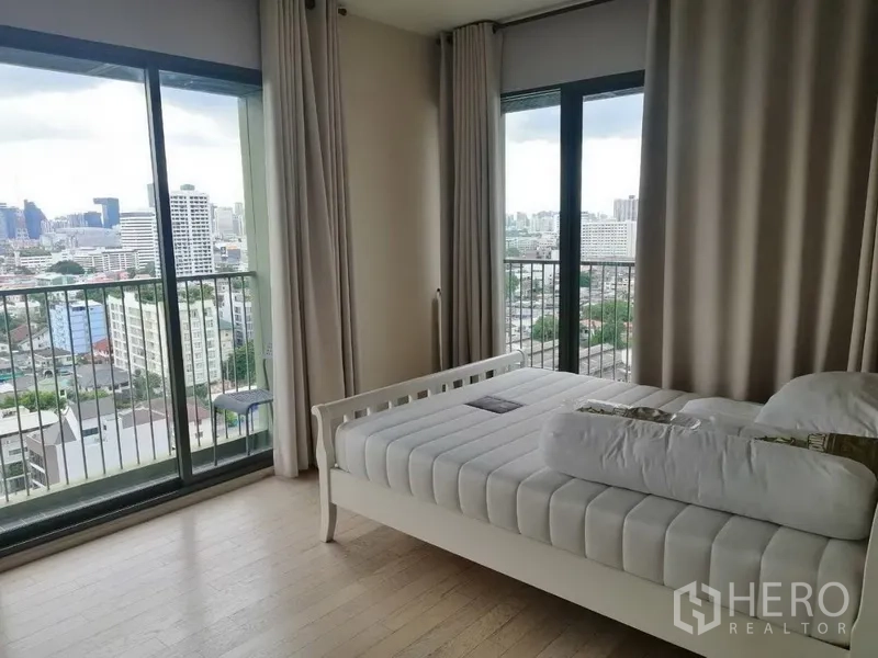 คอนโด ให้เช่าในWatthana, Bangkok - ห้องนอนเตียงสีขาว กระจกบานใหญ่จรดพื้นและระเบียง มองเห็นวิวเมืองกว้าง.