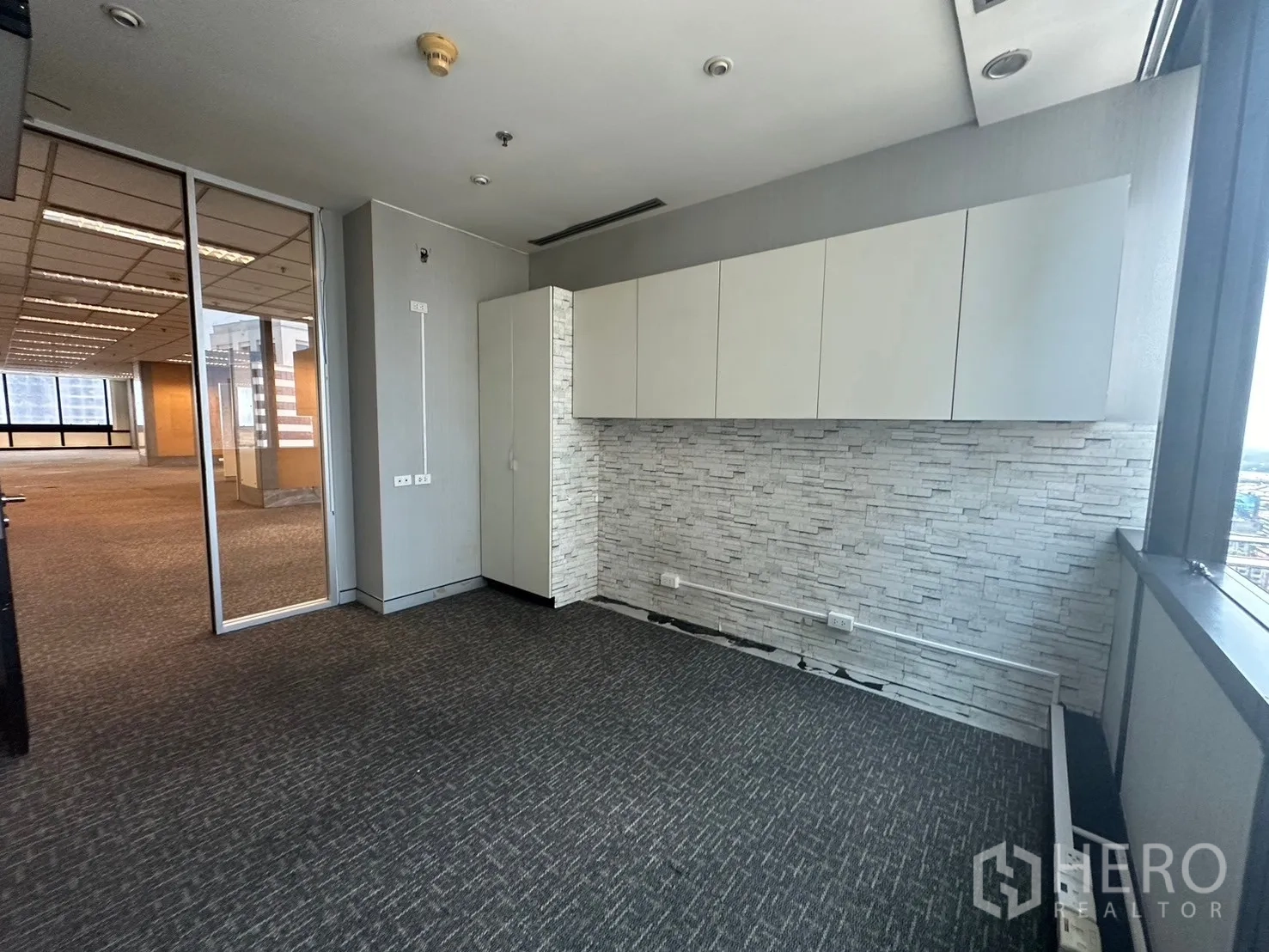 Office Space for rent in Khlong Toei, Bangkok - Compact office with wall cabinets, stone feature wall and a glass partition.