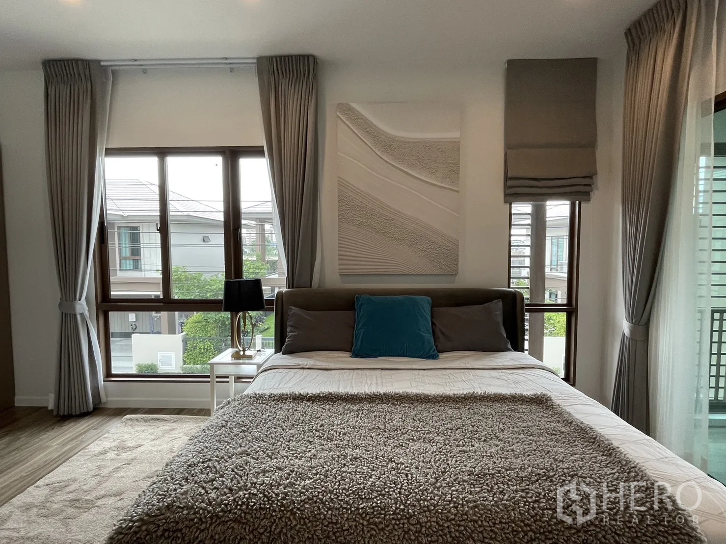 Detached House for rent in Bang Kapi, Bangkok - Master bedroom with bed, large windows, and textured wall art.