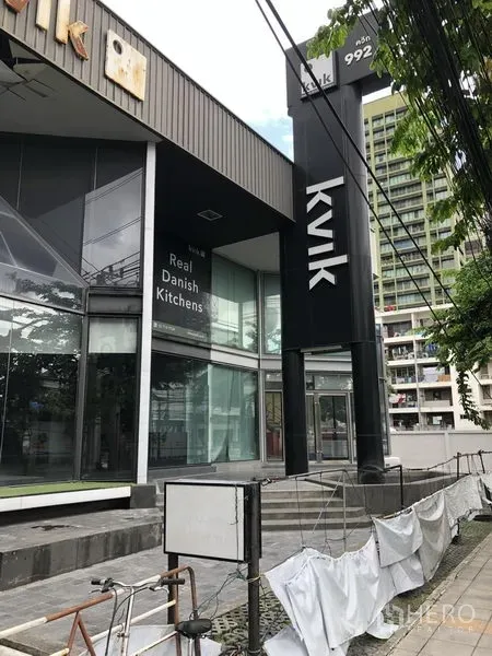 零售空间 出租在Watthana, Bangkok - 商铺外立面带高大门柱、台阶与大面积玻璃入口，位于通罗商圈。