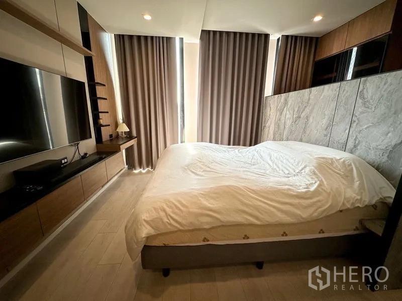公寓 出租在Pathum Wan, Bangkok - 卧室配大床，大理石质感床头与遮光窗帘。