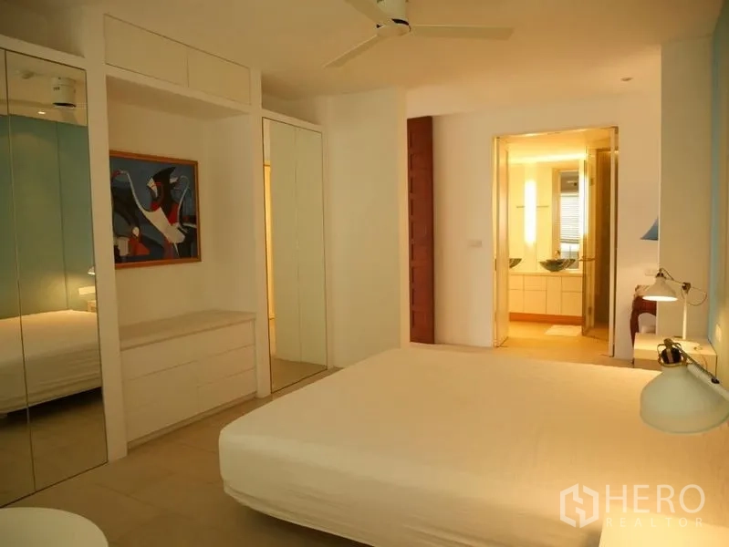 Condominium for rent in Khlong Toei, Bangkok - Master bedroom leading to an ensuite bathroom with warm tones.